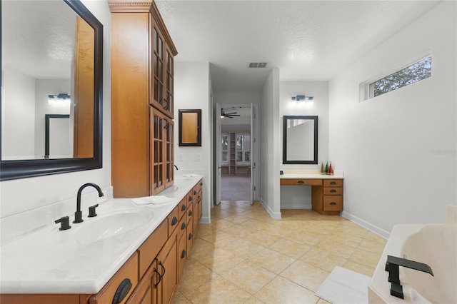 bathroom featuring vanity, tile patterned floors, a bathing tub, ceiling fan, and a textured ceiling