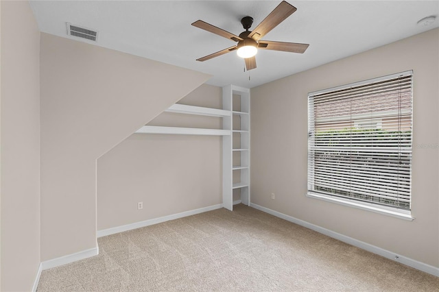 interior space featuring ceiling fan and light colored carpet