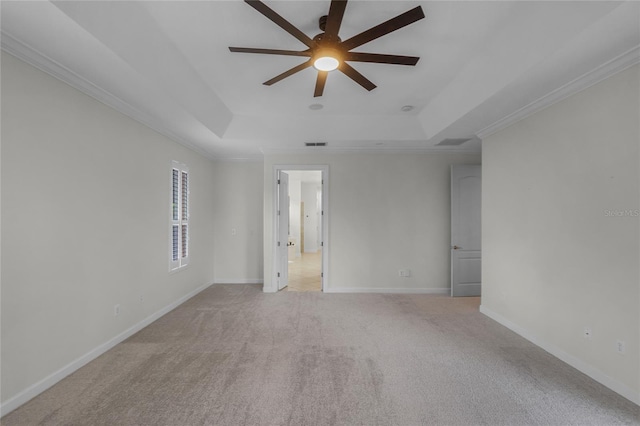 carpeted empty room featuring a tray ceiling, ceiling fan, and ornamental molding