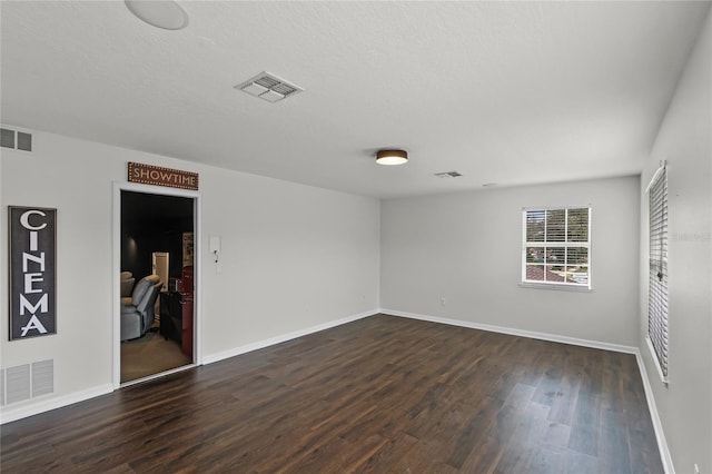 spare room with dark hardwood / wood-style flooring and a textured ceiling