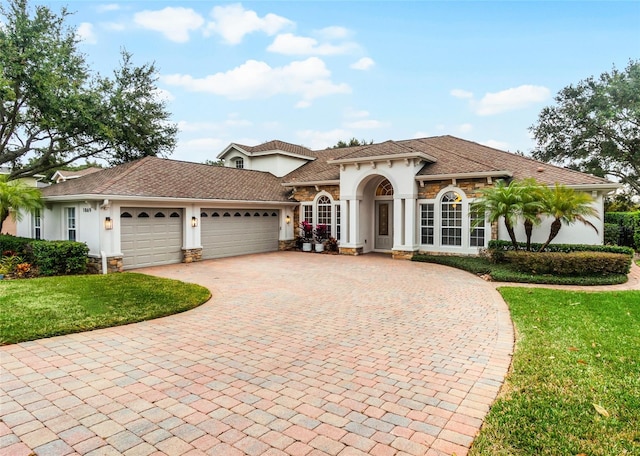 mediterranean / spanish house with a garage and a front yard