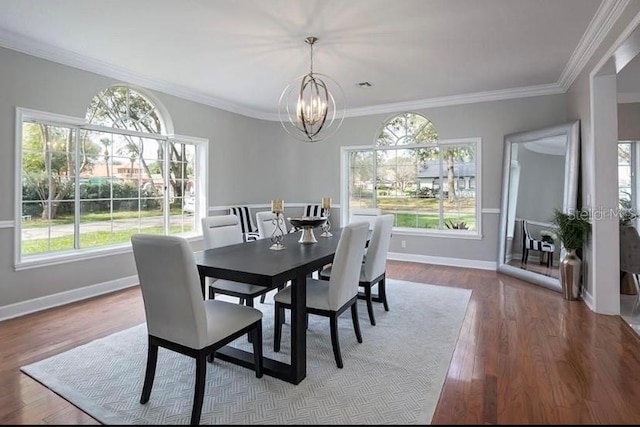 dining room with a chandelier, hardwood / wood-style floors, a wealth of natural light, and crown molding