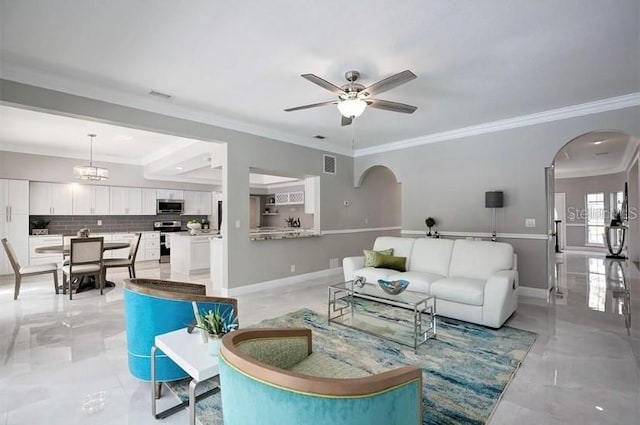 living room with ceiling fan with notable chandelier and crown molding