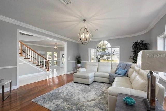 living room featuring hardwood / wood-style flooring, a notable chandelier, and ornamental molding