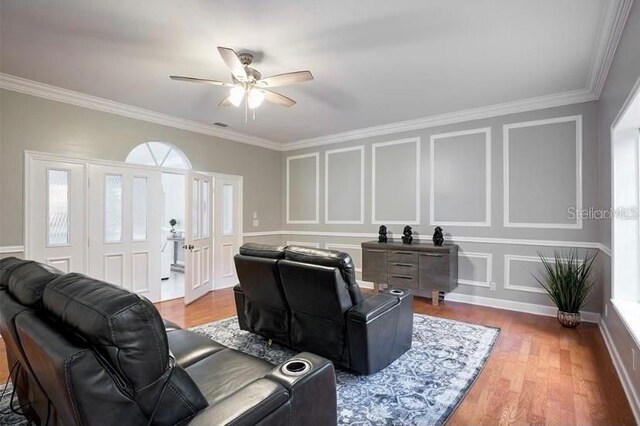 living room with hardwood / wood-style flooring, ceiling fan, and ornamental molding