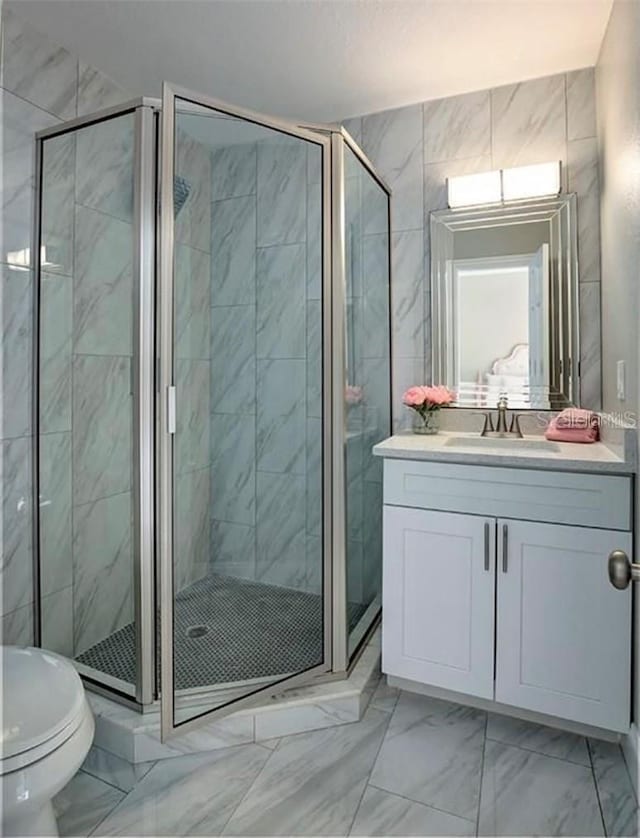 bathroom featuring vanity, toilet, and a shower with shower door