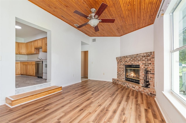 unfurnished living room featuring plenty of natural light, wooden ceiling, and light hardwood / wood-style flooring