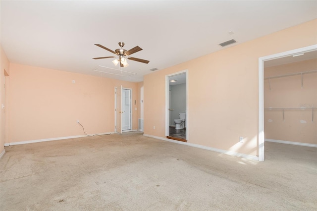 unfurnished bedroom with carpet, ceiling fan, and a spacious closet