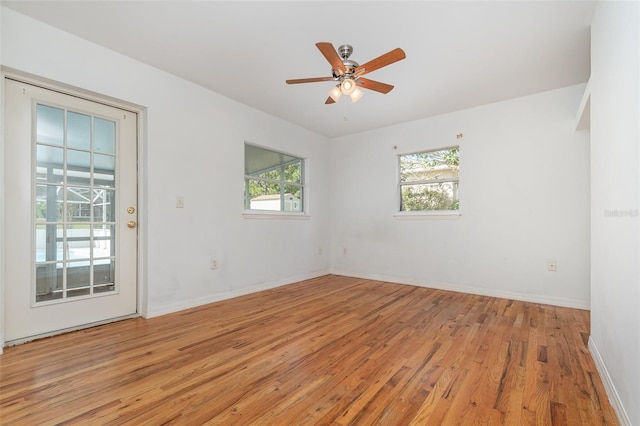 empty room with ceiling fan and light hardwood / wood-style flooring