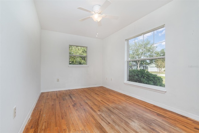 unfurnished room featuring hardwood / wood-style floors, ceiling fan, and a wealth of natural light