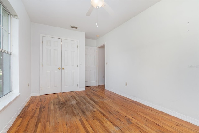 unfurnished bedroom with a closet, ceiling fan, and hardwood / wood-style floors