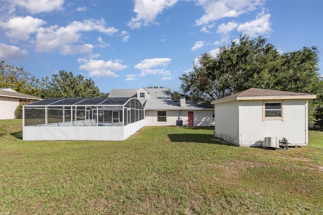 back of property featuring a lawn and a lanai