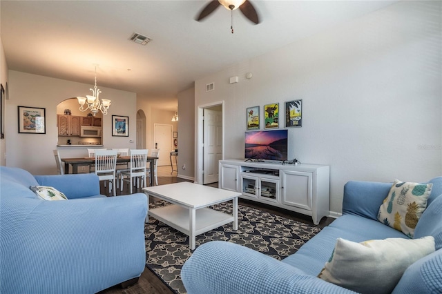 living room featuring ceiling fan with notable chandelier and dark hardwood / wood-style floors