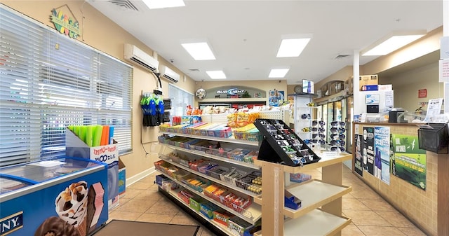 interior space with a wall mounted air conditioner and light tile patterned floors