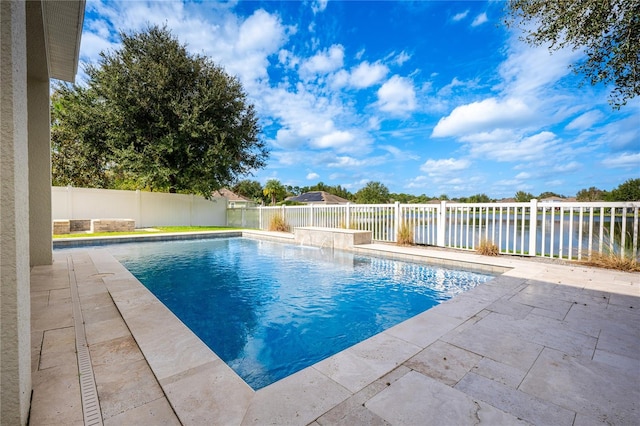 view of swimming pool with a patio area and a water view