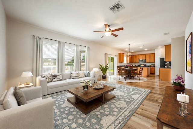 living room with ceiling fan and light wood-type flooring