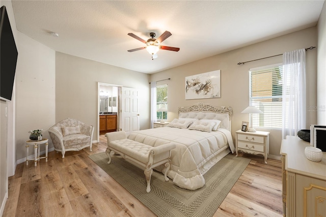 bedroom featuring a textured ceiling, light hardwood / wood-style floors, ensuite bath, and ceiling fan