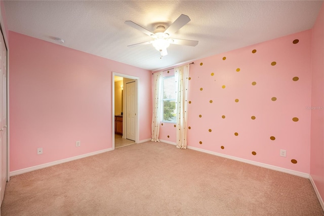 unfurnished bedroom with light carpet, a textured ceiling, and ceiling fan