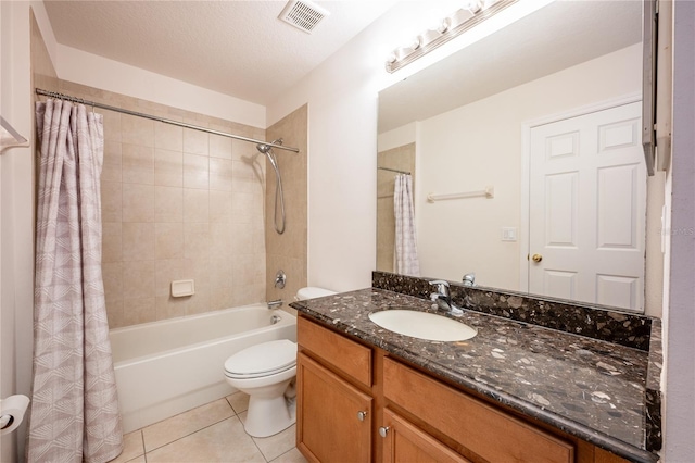 full bathroom with vanity, tile patterned floors, shower / bath combination with curtain, toilet, and a textured ceiling