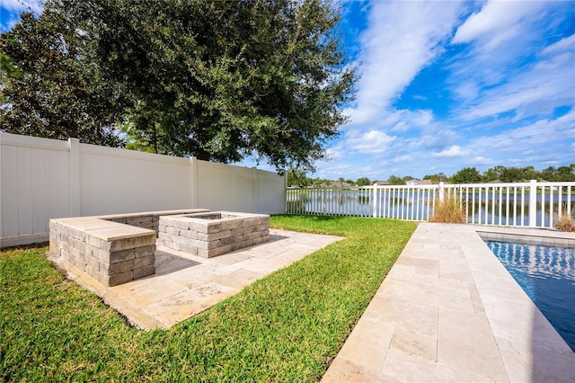 view of yard featuring a water view, a fenced in pool, and a patio