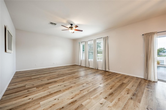 empty room featuring ceiling fan, plenty of natural light, and light hardwood / wood-style floors