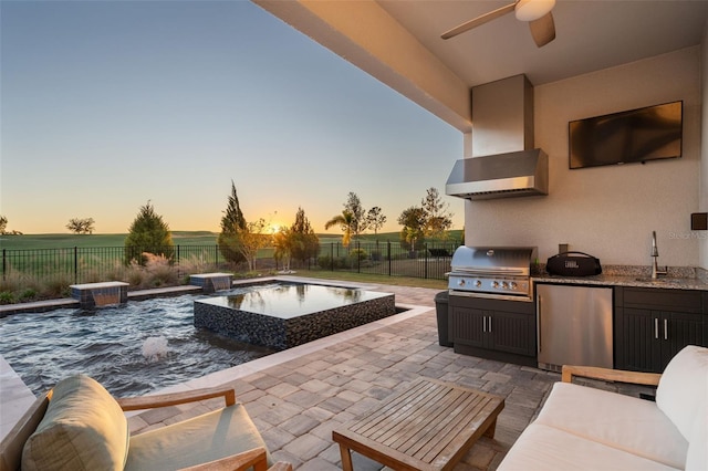 view of patio with sink, exterior kitchen, a grill, pool water feature, and a fenced in pool