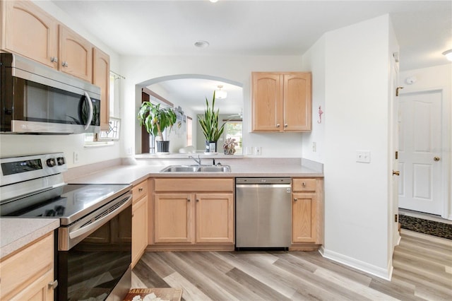 kitchen with light brown cabinetry, light wood-type flooring, sink, and stainless steel appliances