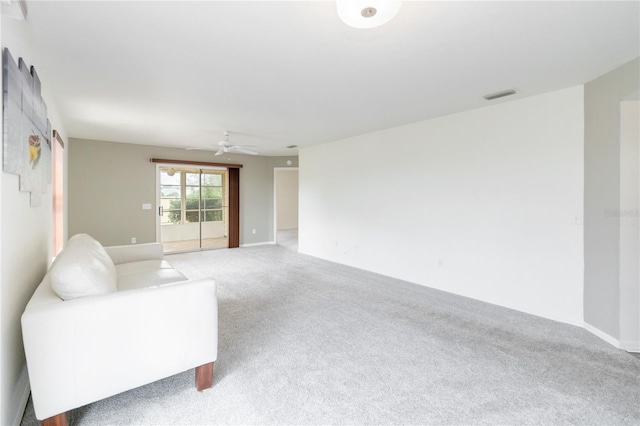 carpeted living room with ceiling fan