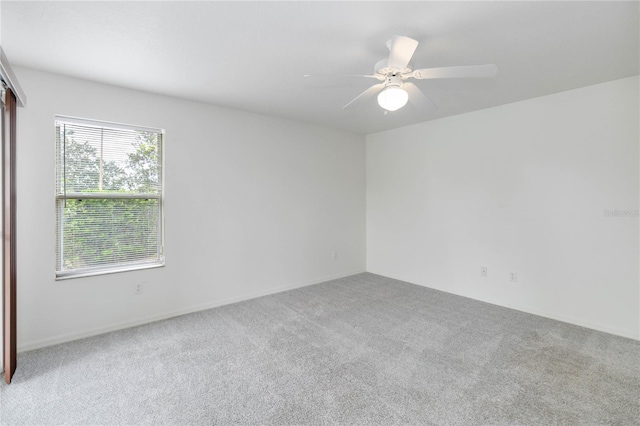 spare room featuring light colored carpet and ceiling fan