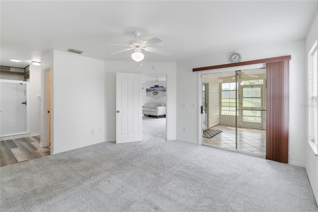 carpeted spare room with ceiling fan