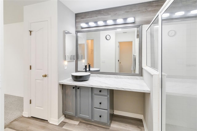 bathroom featuring wood-type flooring, vanity, and a shower with shower door