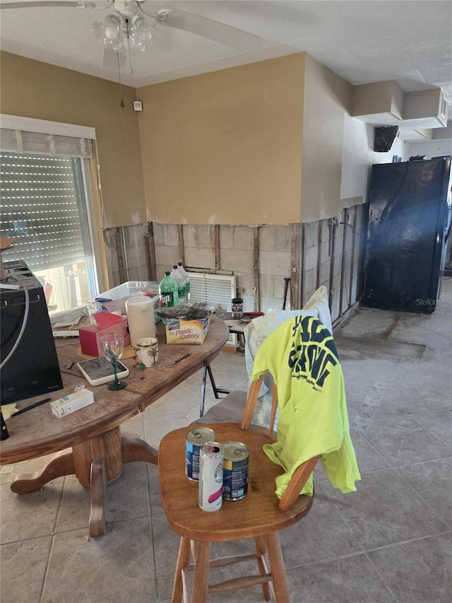 dining space with ceiling fan and a textured ceiling