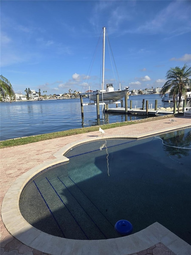 view of pool with a water view and a boat dock