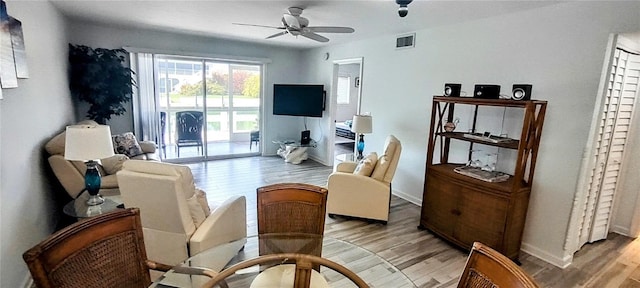 living room with ceiling fan and light hardwood / wood-style floors