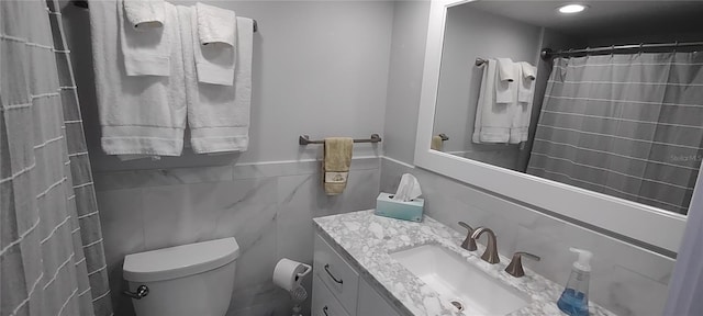 bathroom featuring vanity, toilet, a shower with shower curtain, and tile walls