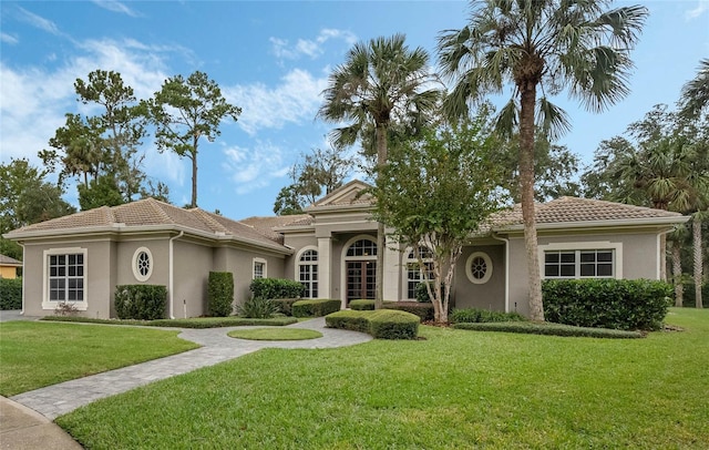 mediterranean / spanish home with a front lawn