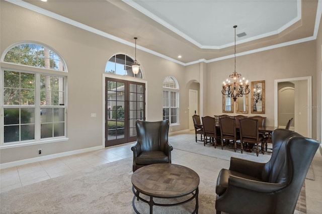 interior space with a high ceiling, ornamental molding, french doors, and a notable chandelier