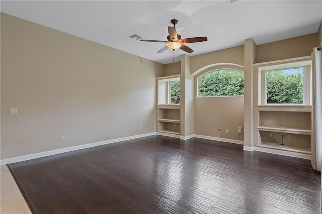 empty room with ceiling fan and dark hardwood / wood-style flooring