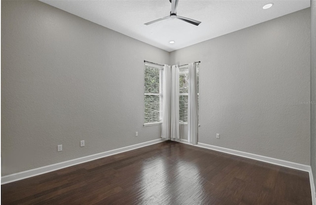 spare room with dark wood-type flooring and ceiling fan