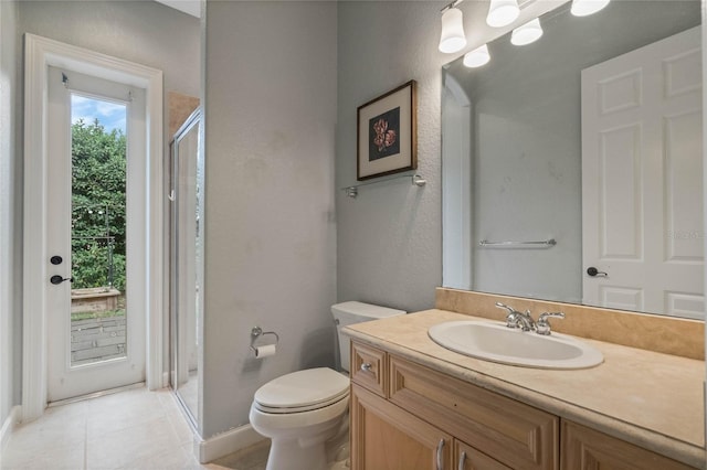 bathroom featuring vanity, a shower with door, tile patterned floors, and toilet