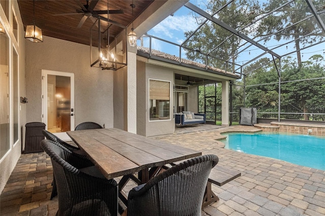 view of swimming pool featuring ceiling fan, glass enclosure, and a patio