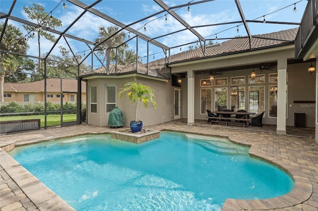 view of swimming pool with a lanai, ceiling fan, and a patio area