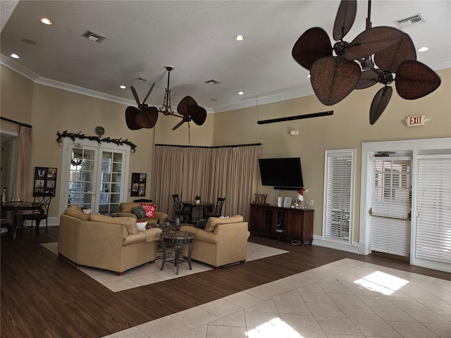 living room with ceiling fan, light tile patterned floors, crown molding, and french doors