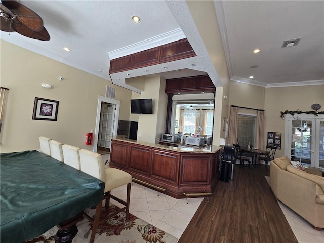 kitchen with crown molding, light tile patterned floors, and ceiling fan