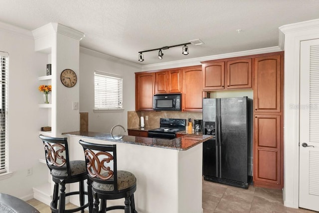 kitchen featuring decorative backsplash, kitchen peninsula, black appliances, ornamental molding, and dark stone countertops