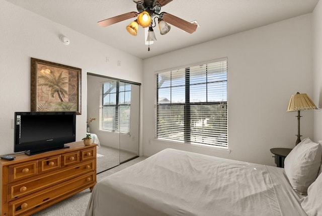 bedroom with a closet, light carpet, and ceiling fan