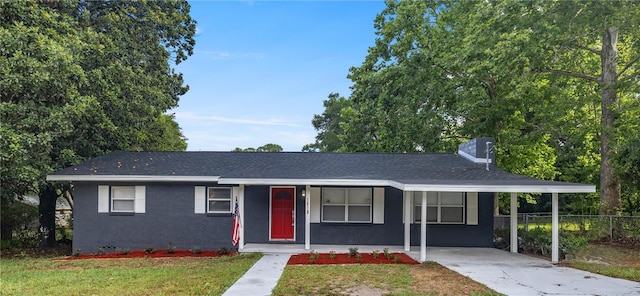 ranch-style house featuring fence, concrete driveway, a front yard, an attached carport, and a chimney