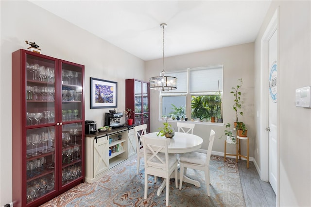 dining area with hardwood / wood-style floors and an inviting chandelier