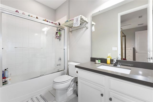 full bathroom with tile patterned flooring, vanity, enclosed tub / shower combo, and toilet