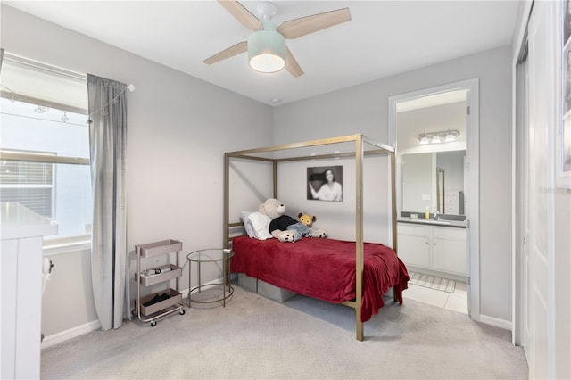 carpeted bedroom with ceiling fan, sink, and ensuite bathroom